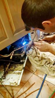 Man repairing water heater with welding techniques